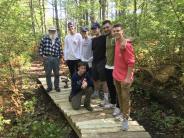 Volunteers help construct a bridge at Doe Farm