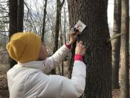 Durham resident Gale Carey puts up Durham property boundary signs at Doe Farm