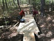 Volunteers build a new trail bridge along the Oyster River Trail