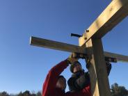 Town volunteers work with Kevin Martin to build a kiosk at Thompson Forest