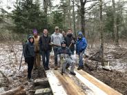 UNH Theta Chi fraternity brothers help build a bridge at Thompson Forest