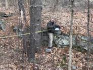 Walter Rous measures the historic cellar hole at Oyster River Forest