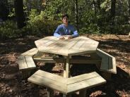 Eric Donovan sitting at the picnic table he built for Eagle Scout